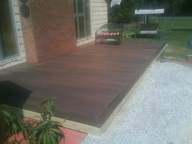 Freshly stained wood deck built against a brick home in Grand Junction